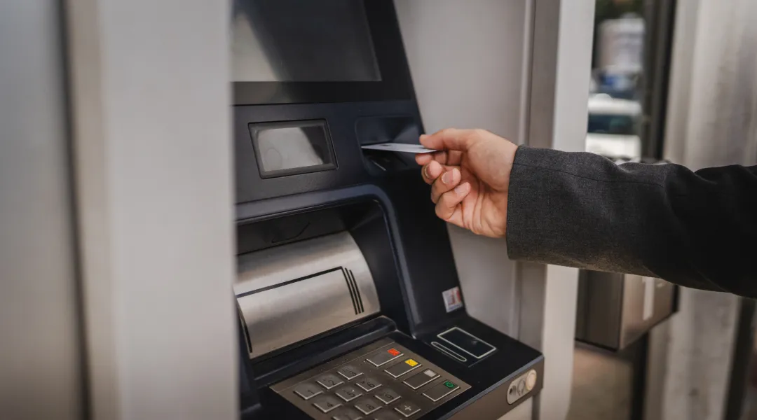 A person using a credit card at an ATM machine for a micro loan.