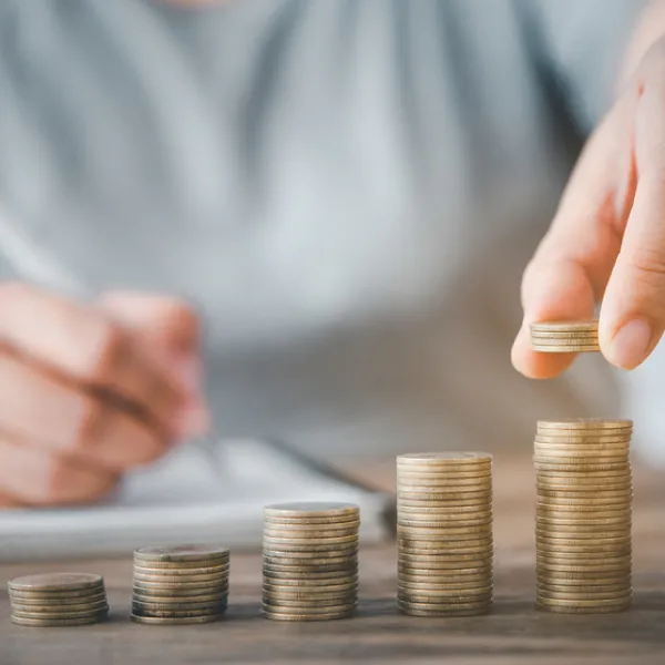 A person stacking coins, representing micro loan concept.