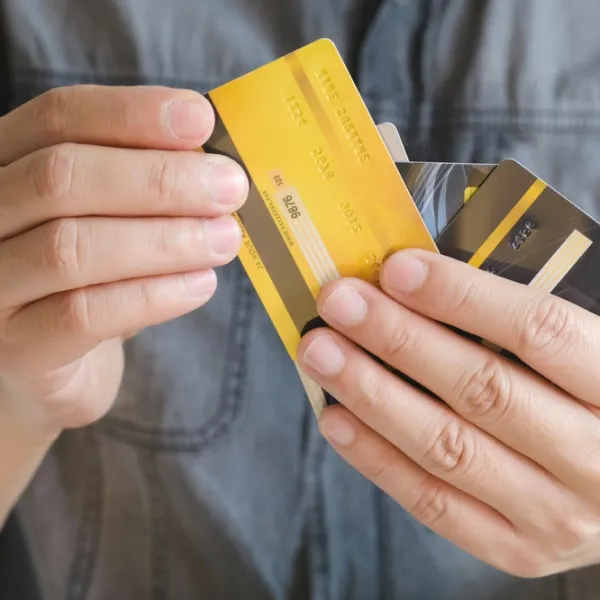 A person holding two credit cards in their hands.